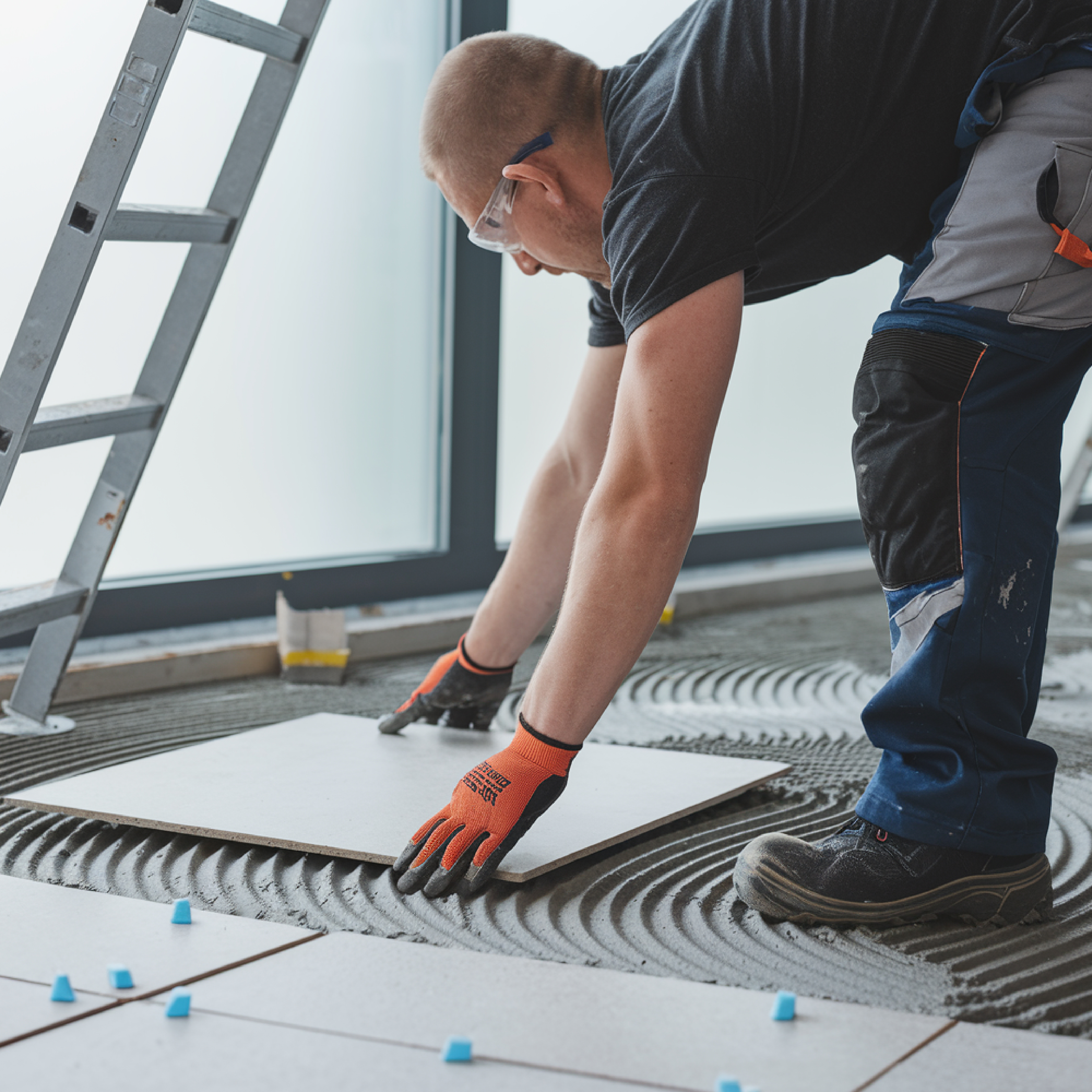  An expert in Bangalore precisely measuring and cutting material for countertops and kitchen installations.